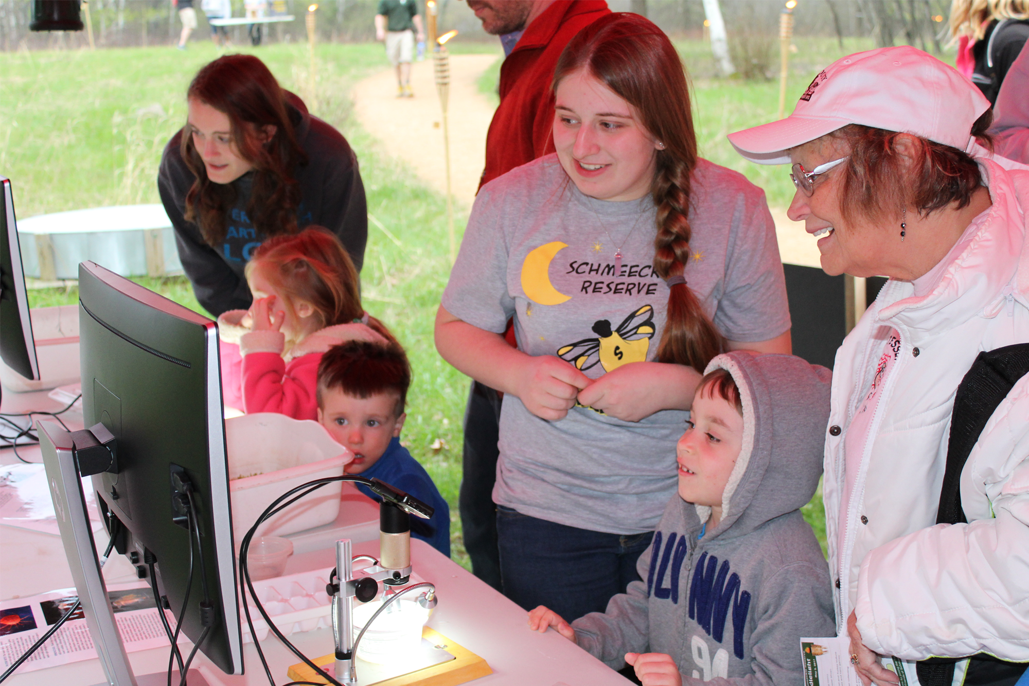 An educator introduces aquatic macroinvertebrates to visitors using microscopes.